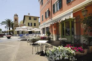 an outdoor patio with tables and chairs and flowers at Hotel Vita Serena in Arma di Taggia
