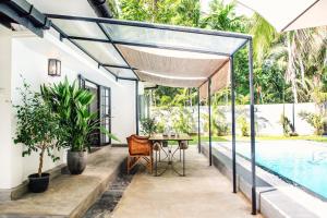 a patio with a table next to a swimming pool at The Cottage Bentota in Bentota