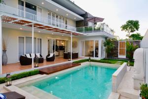 a house with a swimming pool and a house at Villa Arusha Jogja in Sleman
