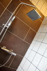a shower in a bathroom with a tile floor at Pension Kupferkanne in Dingolfing