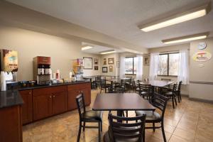 um restaurante com mesas e cadeiras num quarto em Super 8 by Wyndham Ithaca em Ithaca