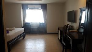 a hotel room with a bed and a window at Wangburapa Grand Hotel in Chiang Mai