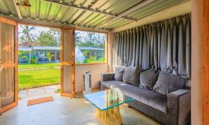 een woonkamer met een bank en een glazen tafel bij Treebo Trend Lands End Beach Resort Morjim in Morjim