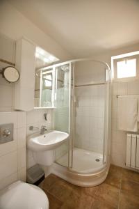a bathroom with a shower and a sink and a toilet at Hotel Makár Sport&Atrium in Pécs
