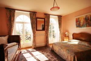 a bedroom with a bed and a large window at Domaine de Sainte Anne in Venoy
