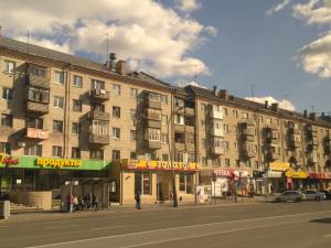 a large building on a city street with a street at Gostevay kvartiry na Melnikayte 101 in Tyumen