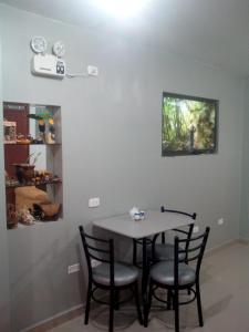uma sala de jantar com uma mesa e quatro cadeiras em Sunset Hostel Airport em Lima