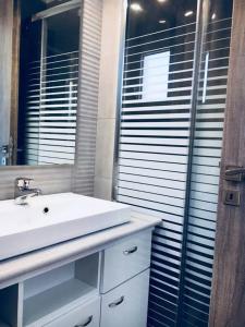 een badkamer met een wastafel en een spiegel bij Stelianas Apartment in Zakynthos