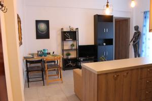 a living room with a table and a kitchen at Stelianas Apartment in Zakynthos