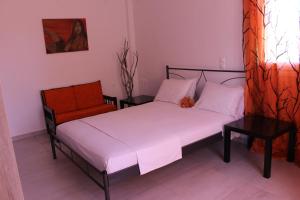 a bedroom with two beds and a chair at Stelianas Apartment in Zakynthos Town