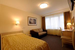 a hotel room with a bed and a television at Belarus Hotel in Minsk