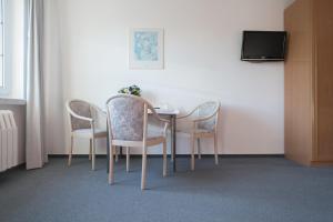 uma mesa de jantar com cadeiras e uma televisão em Haus ÜberLand em Sundhagen-Niederhof