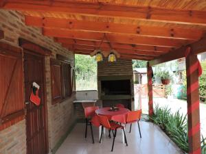 eine Terrasse mit einem Tisch und Stühlen unter Markise in der Unterkunft CABAÑAS LOS COCKERS in Villa General Belgrano