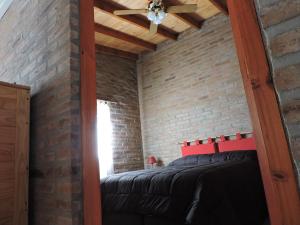 Schlafzimmer mit Ziegelwand und Deckenventilator in der Unterkunft CABAÑAS LOS COCKERS in Villa General Belgrano + 35 Fotos