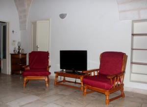 sala de estar con 2 sillas y TV en Ostuni Centro en Ostuni