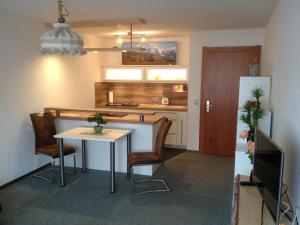 cocina con mesa, sillas y nevera en Haus Alpensonne en Oberstaufen