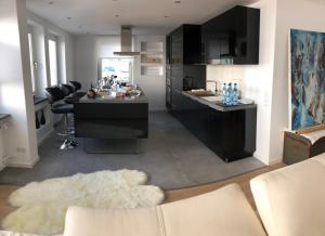 a kitchen and living room with black cabinets and a couch at Apartment Central Würzburg in Würzburg