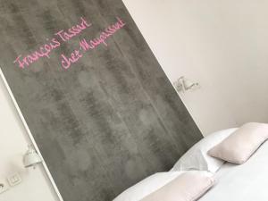 a bedroom with a chalkboard with a bed and two pillows at Hotel Chalet De L'isere in Cannes
