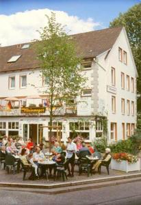 een groep mensen die aan tafels voor een gebouw zitten bij Haus Steinmeyer in Bad Pyrmont