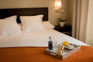 a tray of food and drinks on a bed at Suites Viena Plaza de España in Madrid