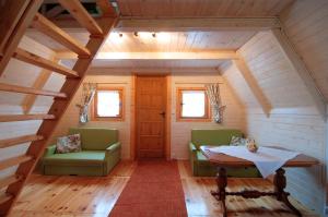 ウストカにあるBajeczne domkiの緑の椅子2脚とテーブルが備わる客室です。