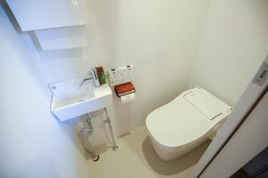 a small bathroom with a toilet and a sink at Tinys Yokohama Hinodecho in Yokohama