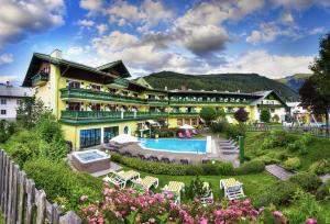 um hotel com piscina e jardim em Hotel Sommerhof em Gosau