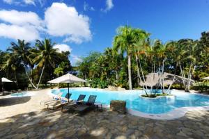 a beach area with a pool, chairs, and umbrellas at Blue JackTar in San Felipe de Puerto Plata