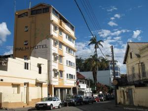 a white car parked in front of a building at Palm Hotel in Antananarivo