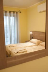 riflessione di una camera con due letti e uno specchio di Hotel Ristorante Piccadilly a Santhià