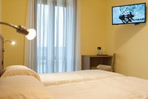 una camera con letto e TV a parete di Hotel Ristorante Piccadilly a Santhià