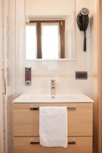 bagno con lavandino e specchio di Hotel Ristorante Piccadilly a Santhià