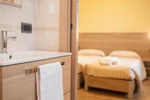 bagno con lavandino e 2 letti di Hotel Ristorante Piccadilly a Santhià