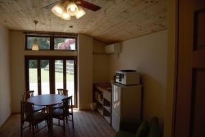 a kitchen with a table and chairs and a refrigerator at Mountain Home Lodge in Deer Park in Nara