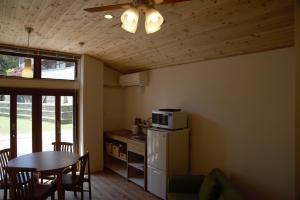 a kitchen with a table and a white refrigerator at Mountain Home Lodge in Deer Park in Nara