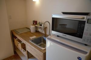 a kitchen with a microwave on top of a refrigerator at Mountain Home Lodge in Deer Park in Nara