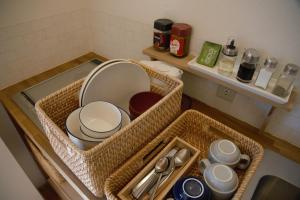 a bathroom counter with baskets and dishes on a sink at Mountain Home Lodge in Deer Park in Nara