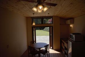 a dining room with a table and a ceiling fan at Mountain Home Lodge in Deer Park in Nara