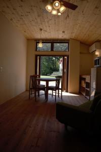 ein Esszimmer mit einem Tisch, Stühlen und einem Fenster in der Unterkunft Mountain Home Lodge in Deer Park in Nara