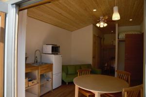 a kitchen and dining room with a table and a refrigerator at Mountain Home Lodge in Deer Park in Nara