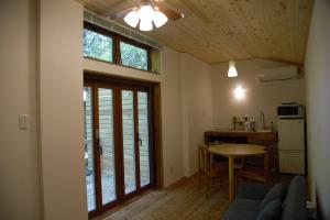 a living room with a table and a kitchen at Mountain Home Lodge in Deer Park in Nara