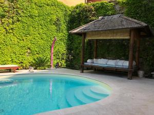 uma piscina com um gazebo e uma cama em Locanda Agli Angeli em Gardone Riviera