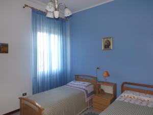 1 dormitorio azul con 2 camas y ventana en Casa dei Pini, en Cortona 41 fotos más