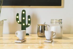a table with two coffee cups and a cactus at Casa Anmori in Ostuni +18 photos
