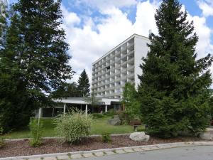 een groot gebouw met een boom ervoor bij Haus Bergland in Neureichenau