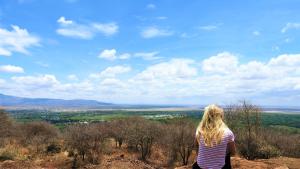 a woman standing on top of a hill looking at a city at Migombani Camp in Mto wa Mbu