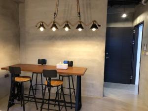 a dining room table with stools under a chandelier at Kenting Peninsula Inn in Kenting