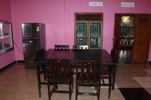 a dining room with a table and a refrigerator at El Shaddai in Mannar