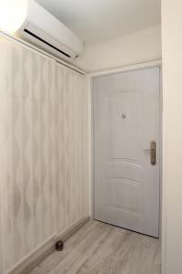 una habitación vacía con una puerta blanca y una pared en Apartma Mery, en Piran