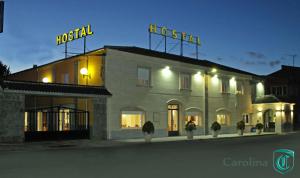 a building with a hotel sign on top of it at Hostal Restaurante Carolina in Pedrosillo el Ralo